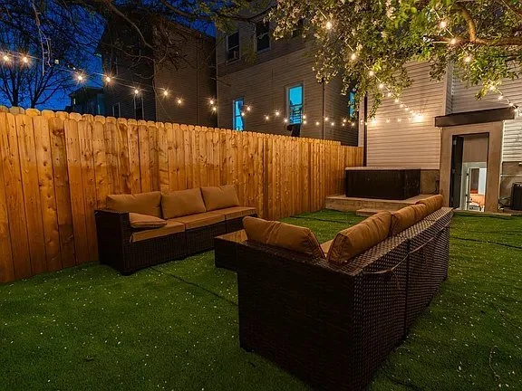 55 Atlantic — backyard lounge with string lights and outdoor sofas