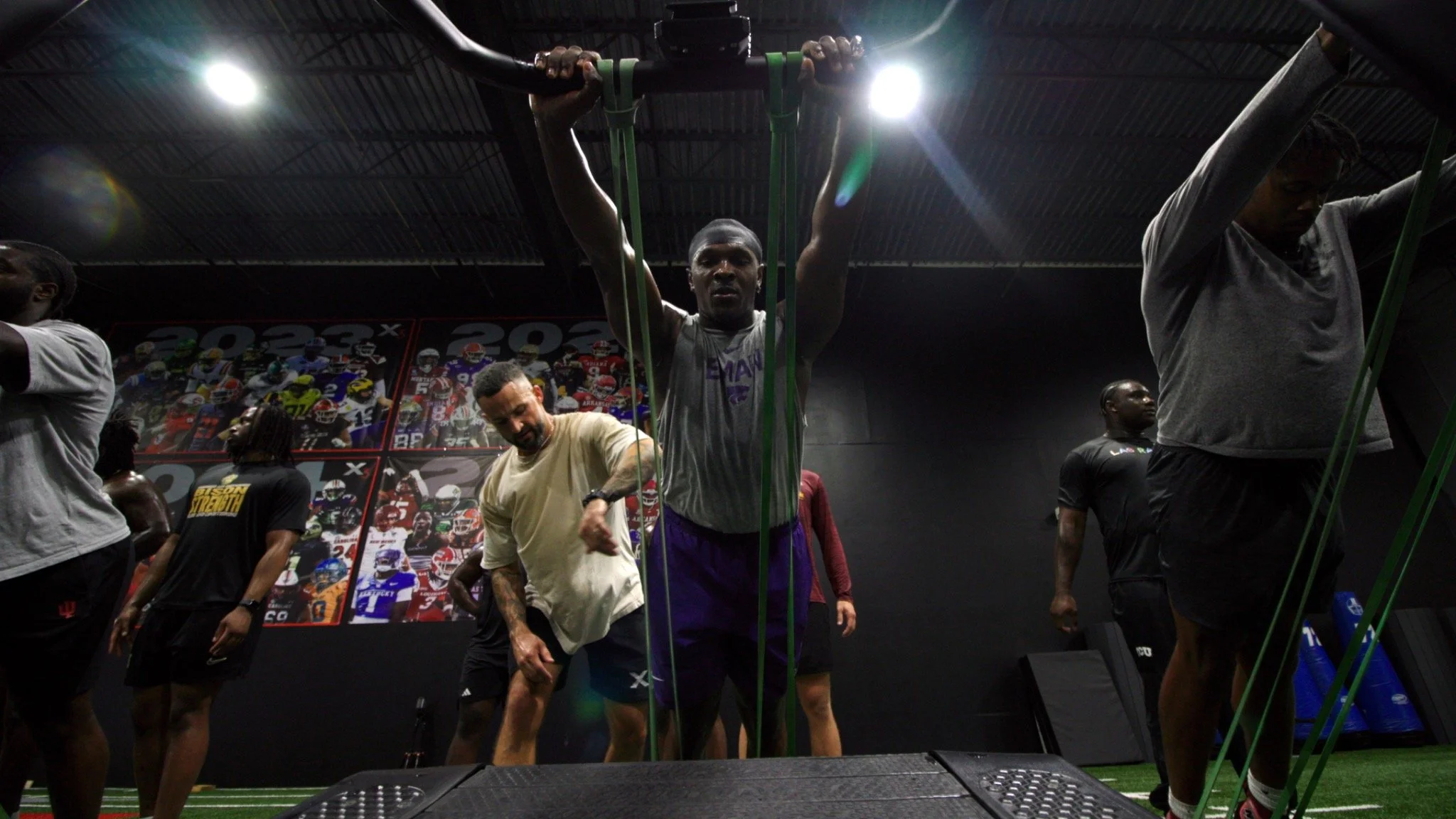 Athlete performing overhead resistance training with a coach