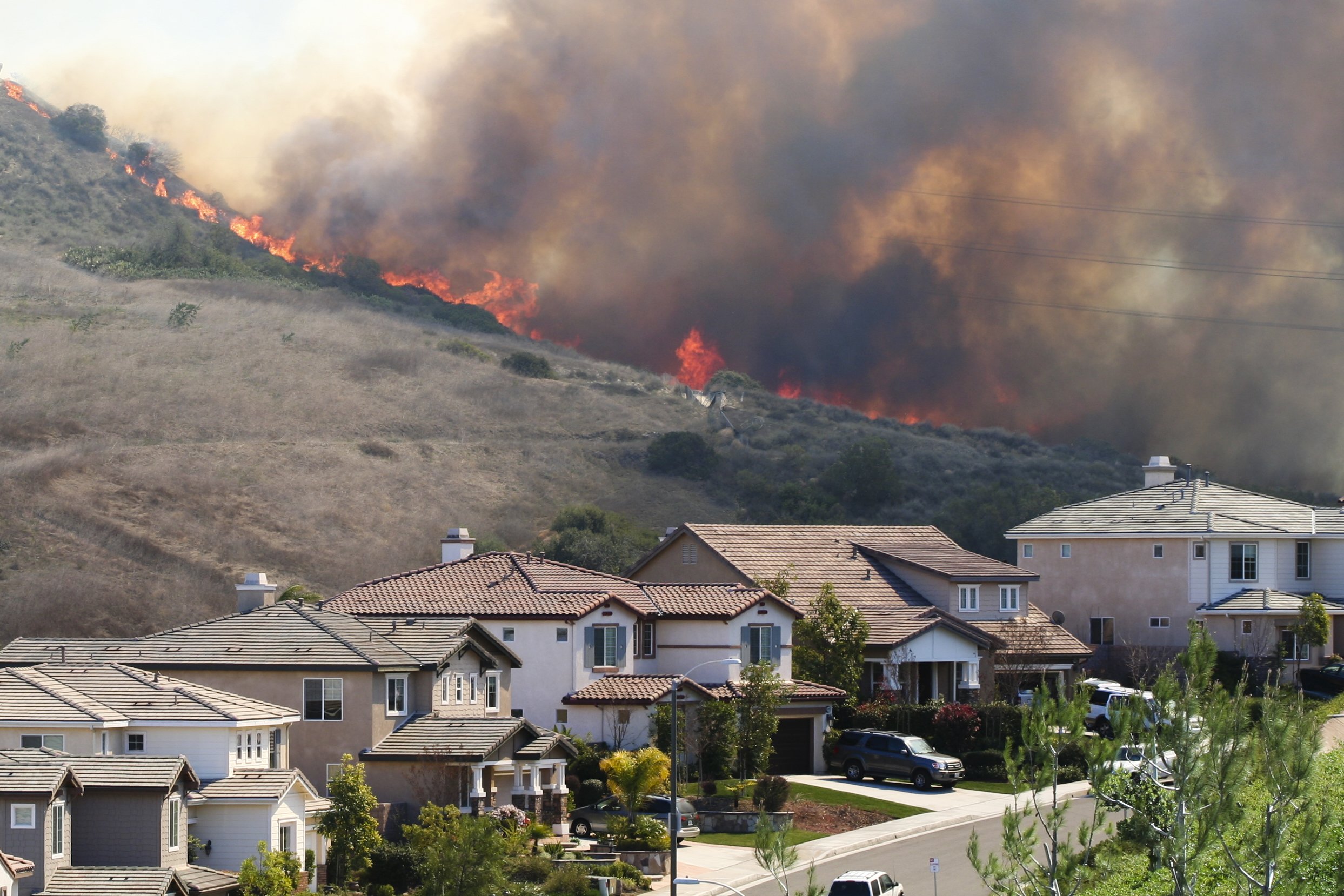 Wildfire burning along a Southern California hillside above nearby properties