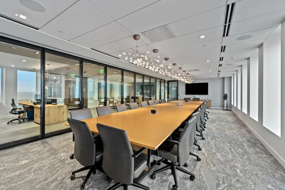 Illustrative glass-enclosed meeting room with a wood conference table and upholstered chairs