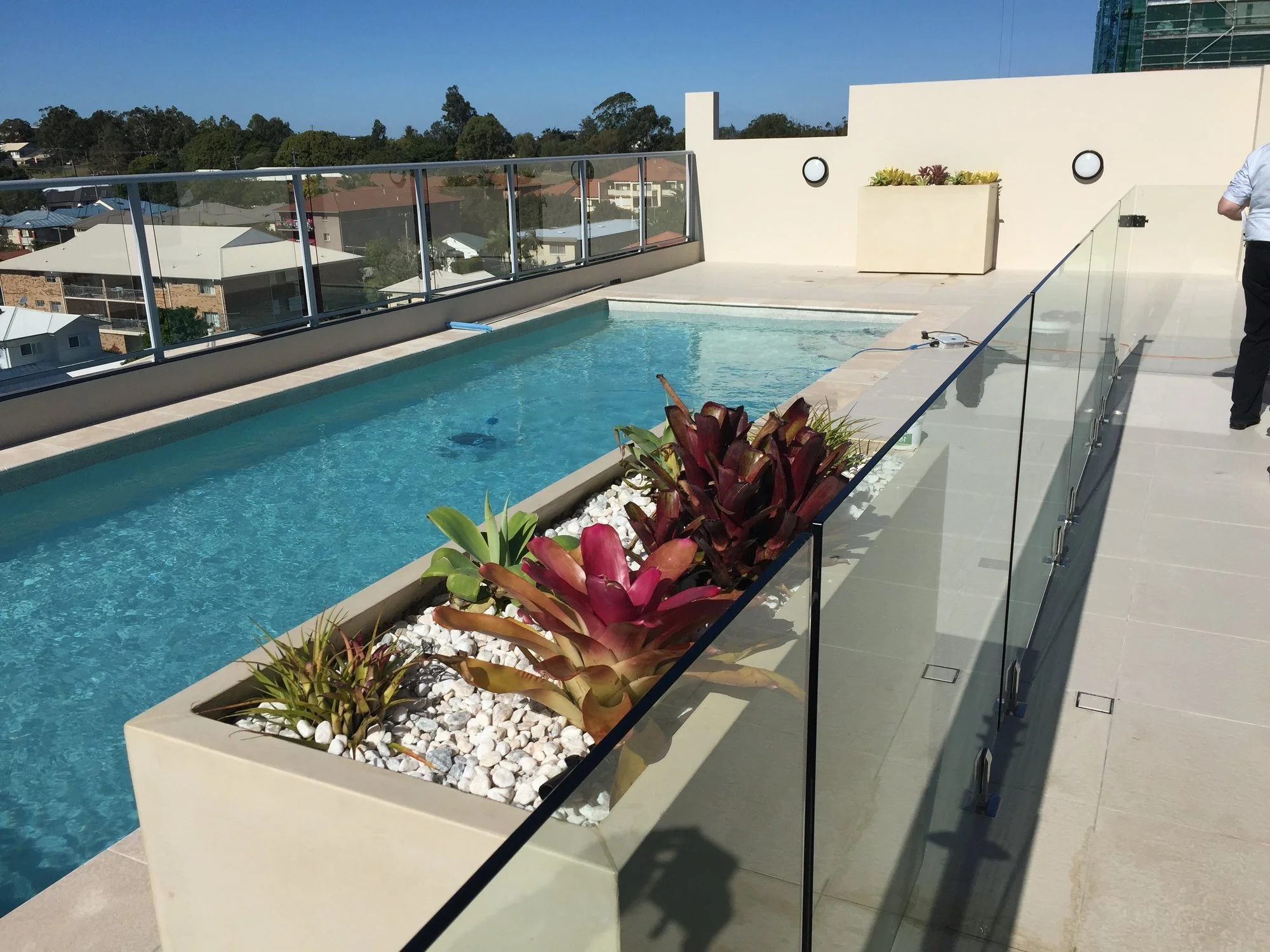 The rooftop pool and terrace with a glass balustrade and views over the northern suburbs