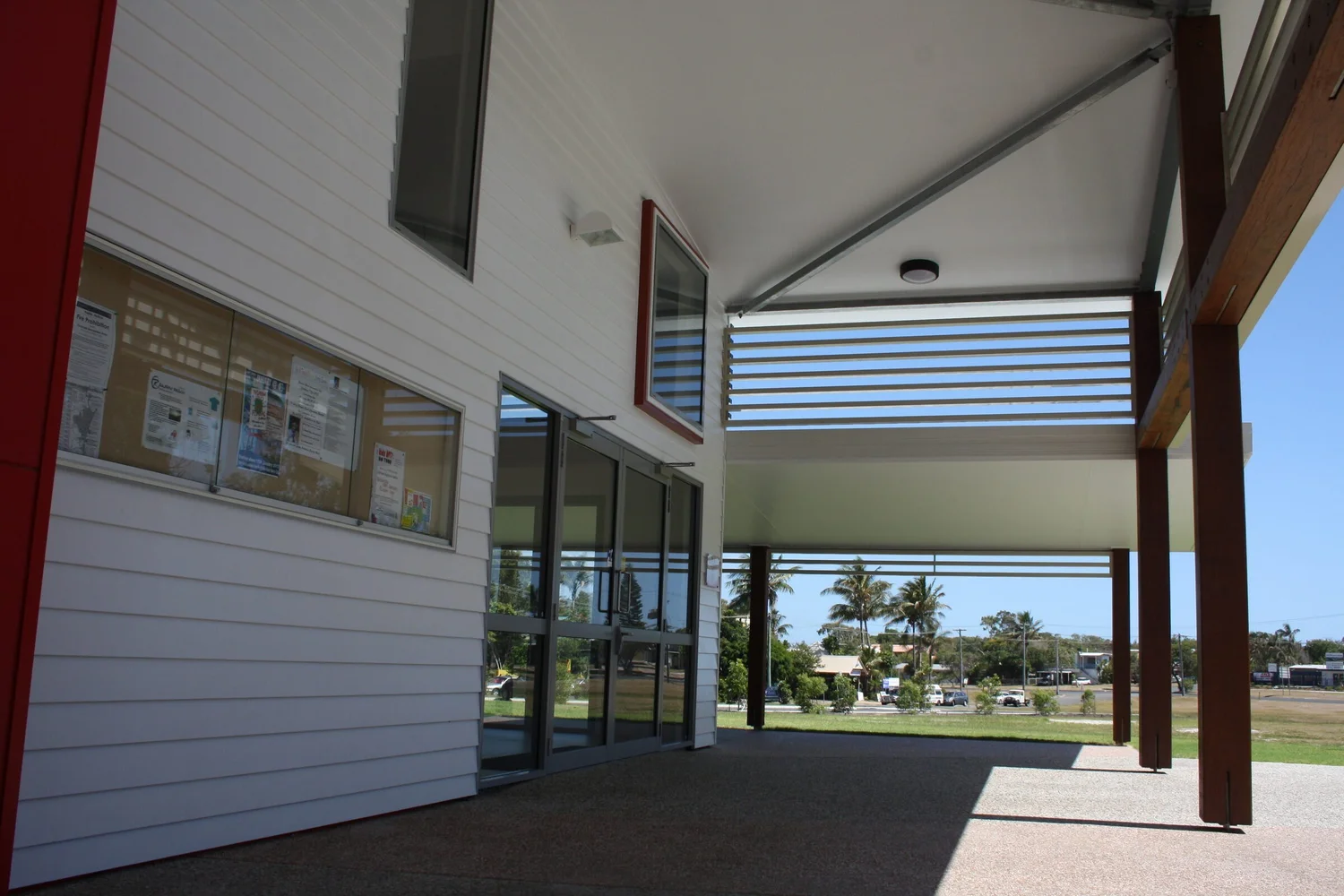 The deep verandah between the white weatherboard wall and the timber posts, looking out to the street