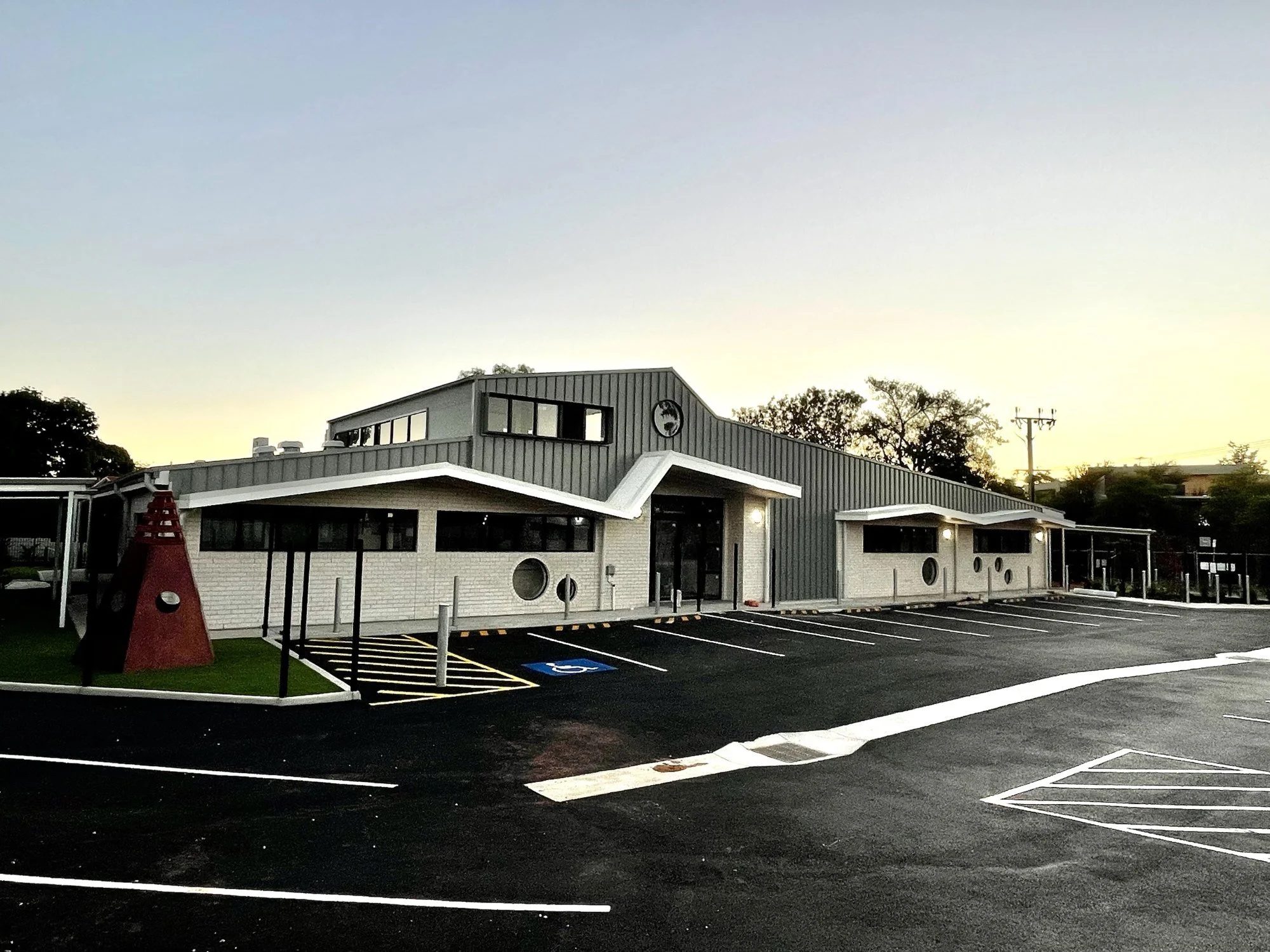 Guardian Childcare Centre at dusk, its folded white canopy lit along the front