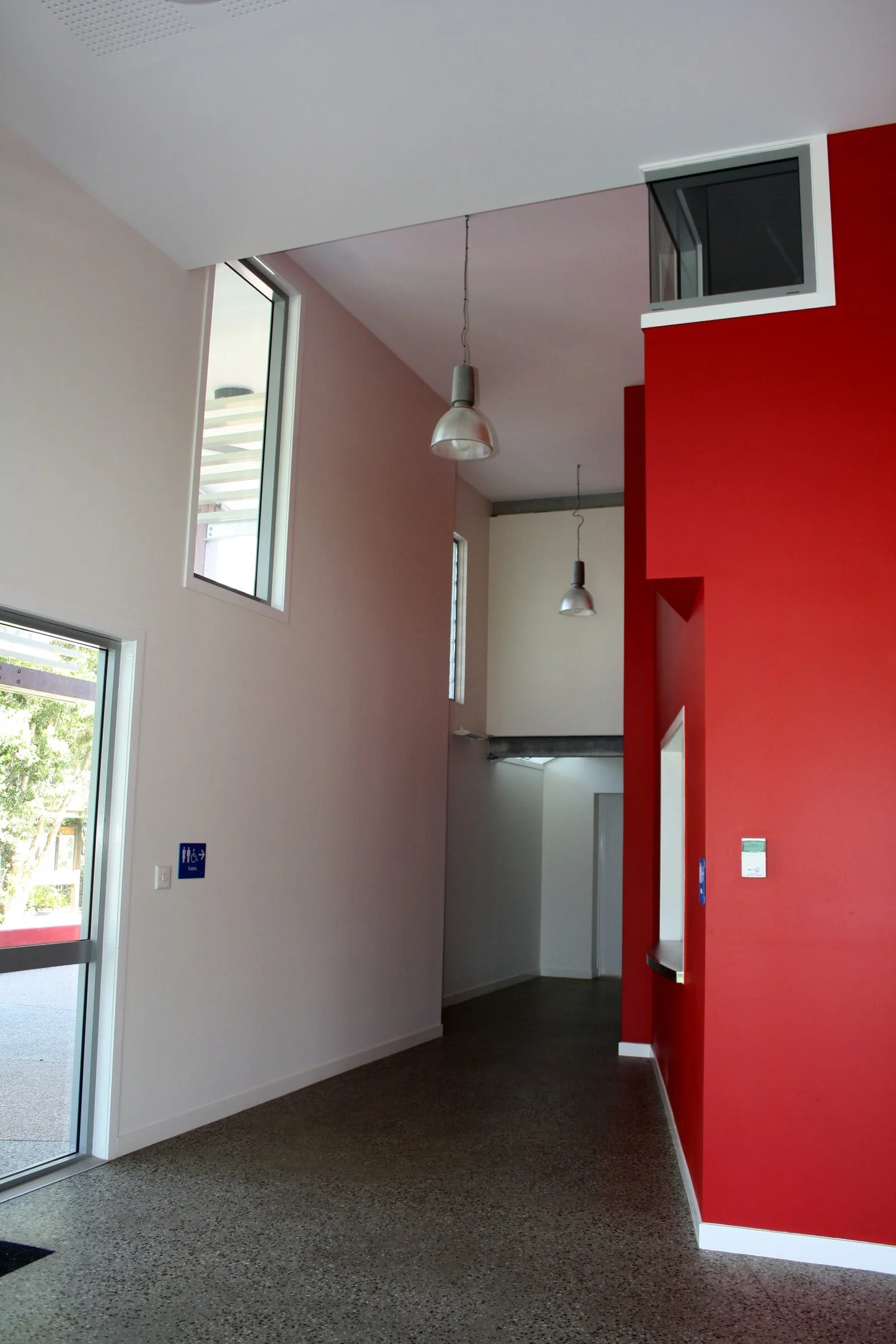 The tall foyer with its red wall and clerestory window