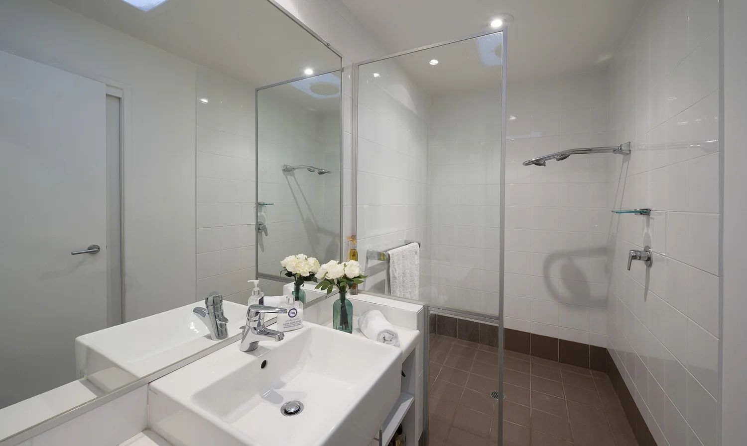 Ensuite with a frameless glass shower and double basin