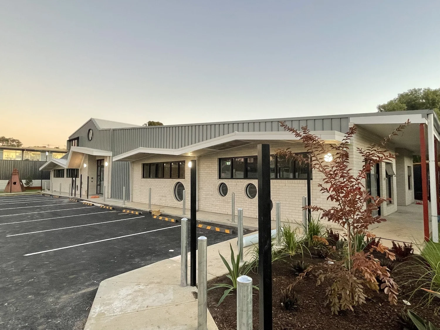 The front of the building seen past new planting