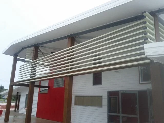 Pale louvres screening the verandah between timber posts