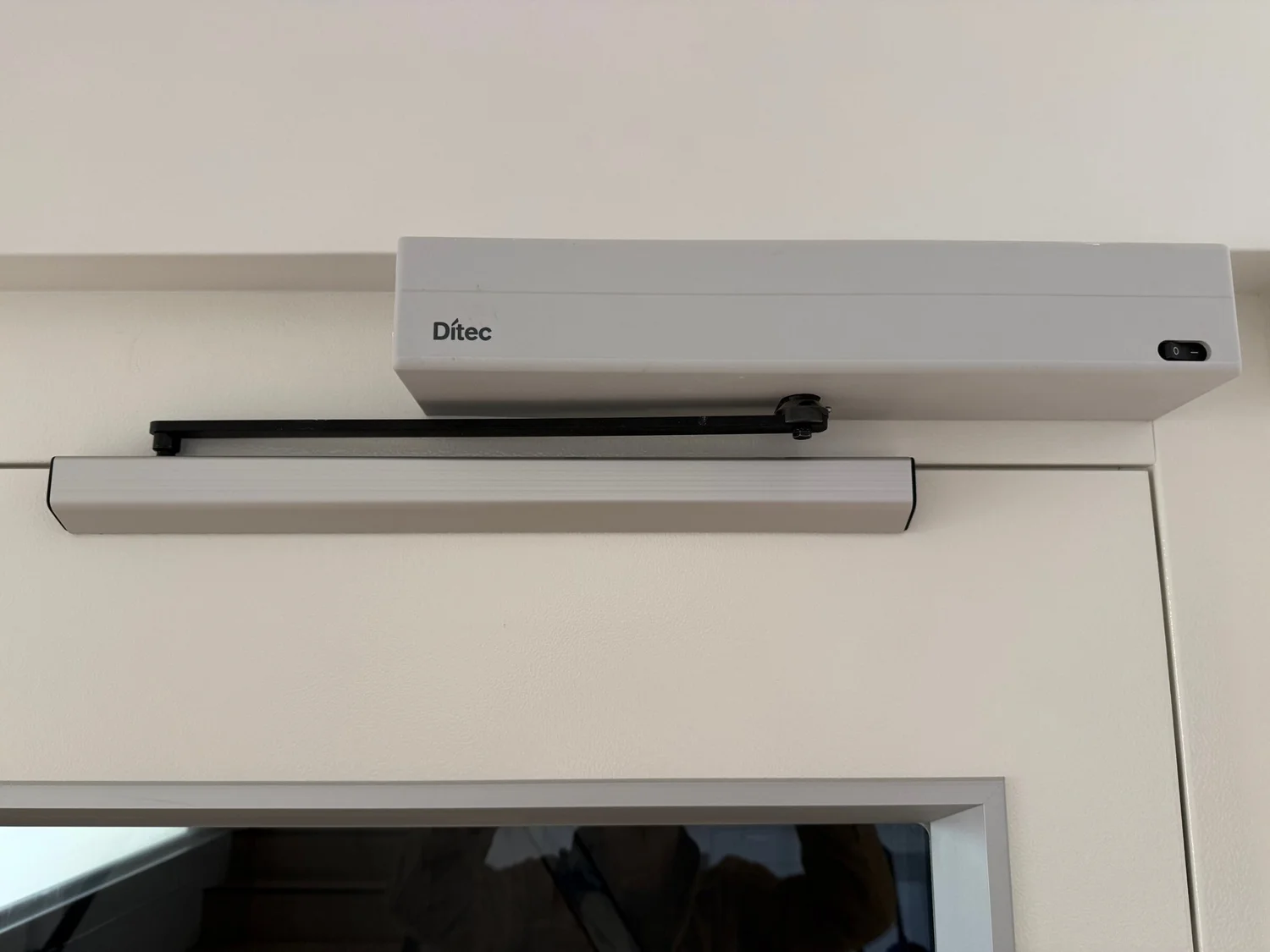 An automatic door operator fitted above a door