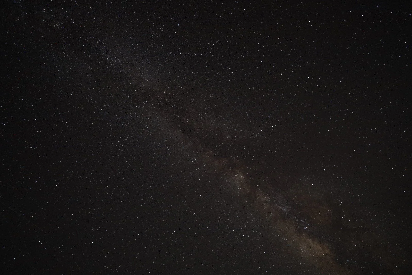 A star-filled night sky with a faint diagonal band of light.