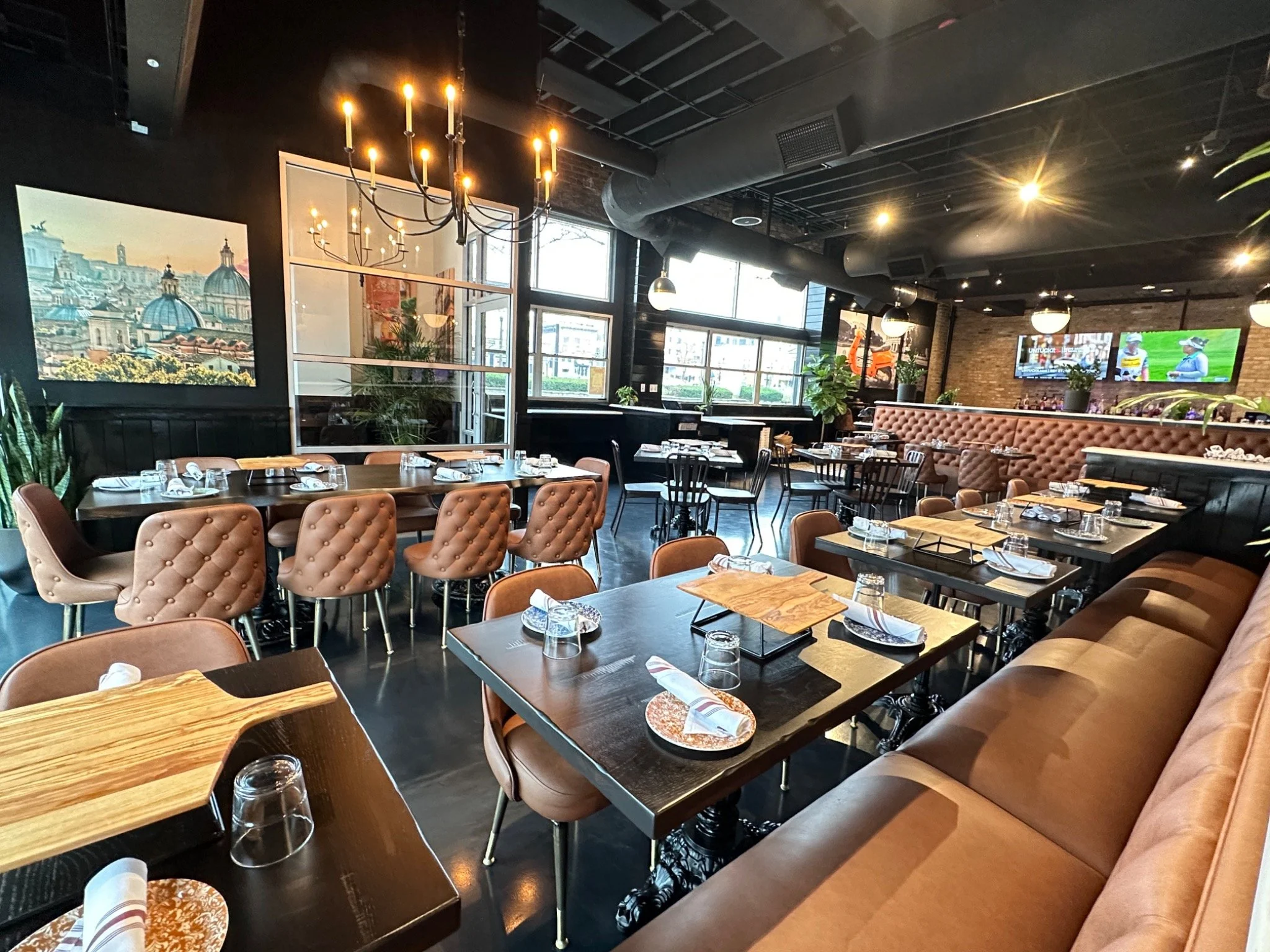 Ella’s Elmhurst dining room with family tables, leather booths, and the bar beyond