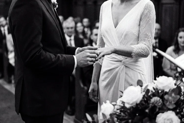 A ring exchange at the altar, guests watching from the pews