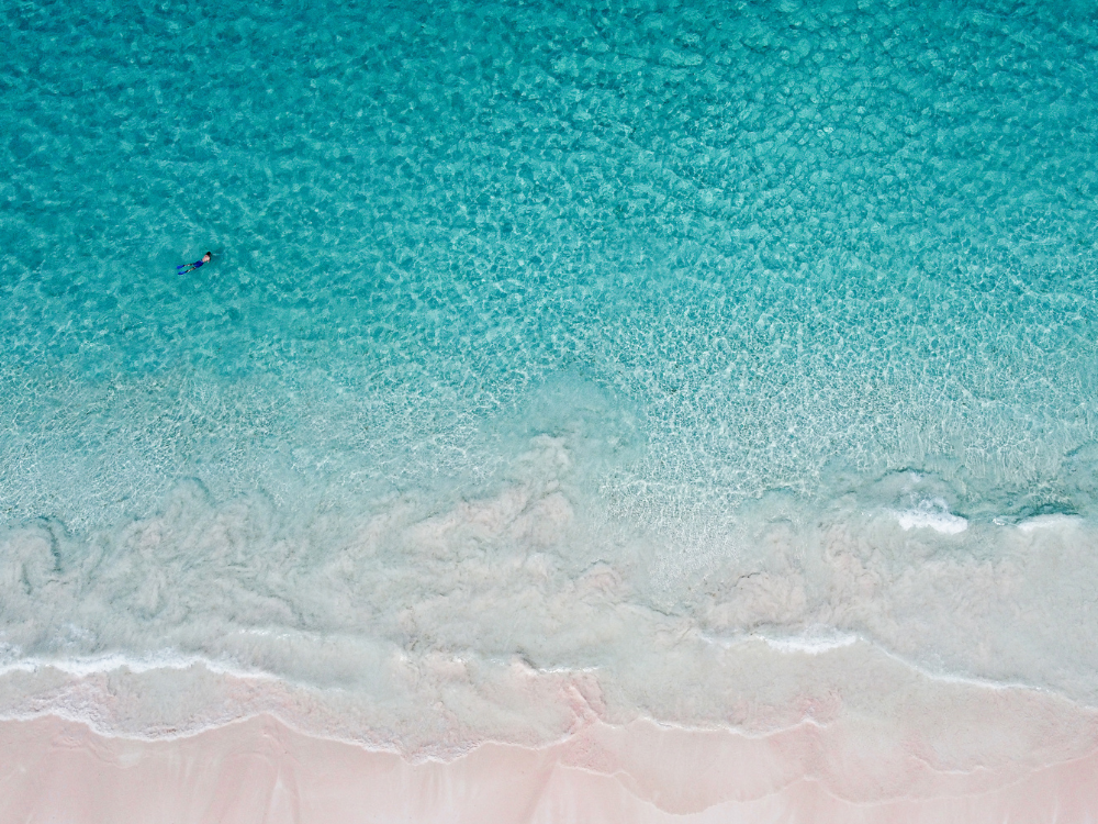 Waves washing over pink sand