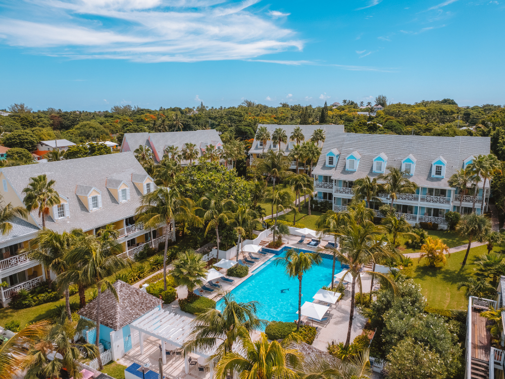 Aerial view of resort villas and pool surrounded by palm trees