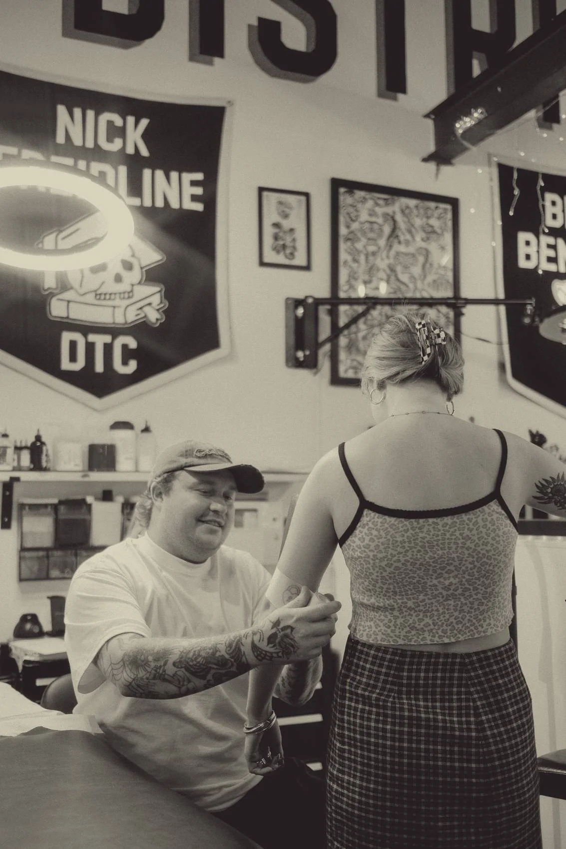 Nick Freidline checking a client's fresh tattoo