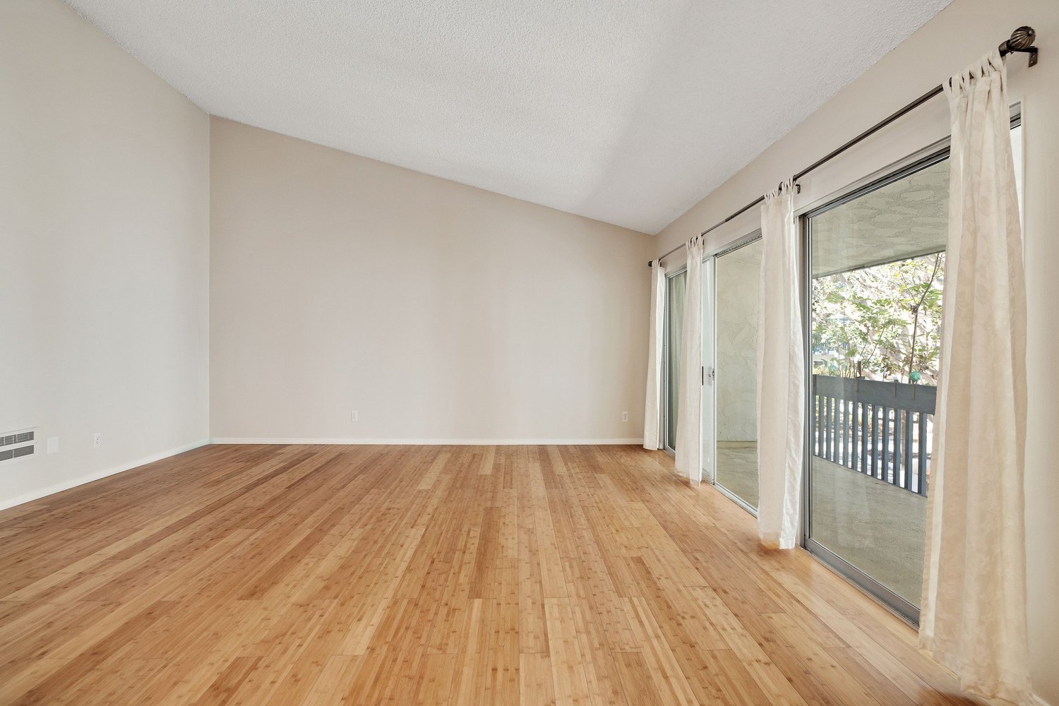 Living room as is, with bamboo floors and sliding doors to the balcony