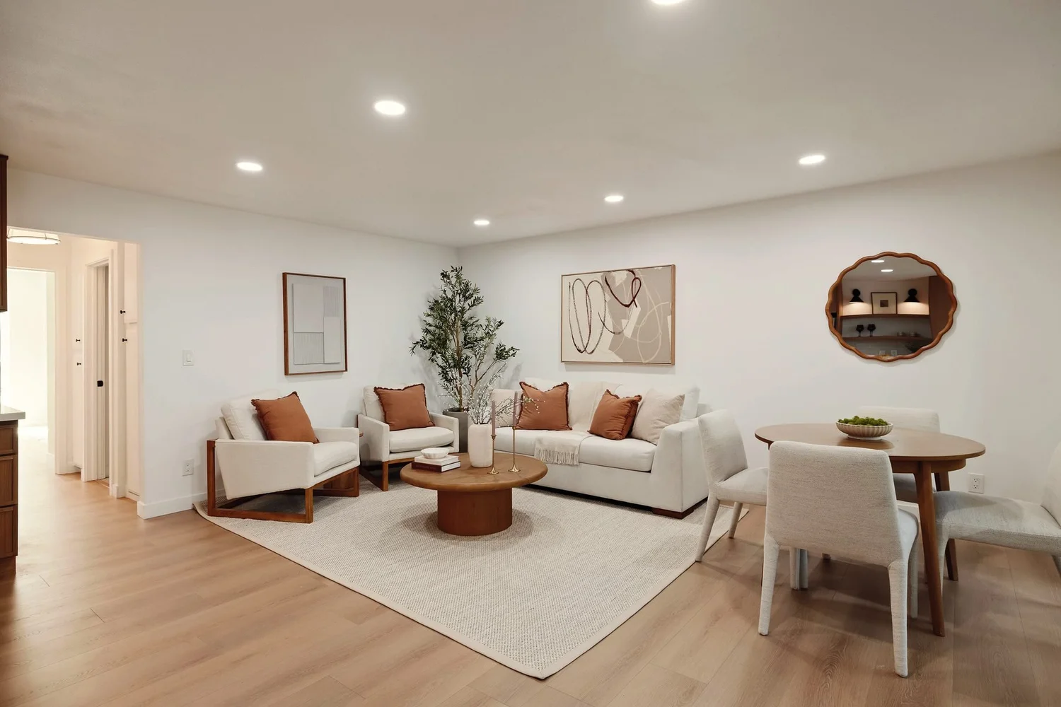 A staged living room with warm oak floors and soft natural light