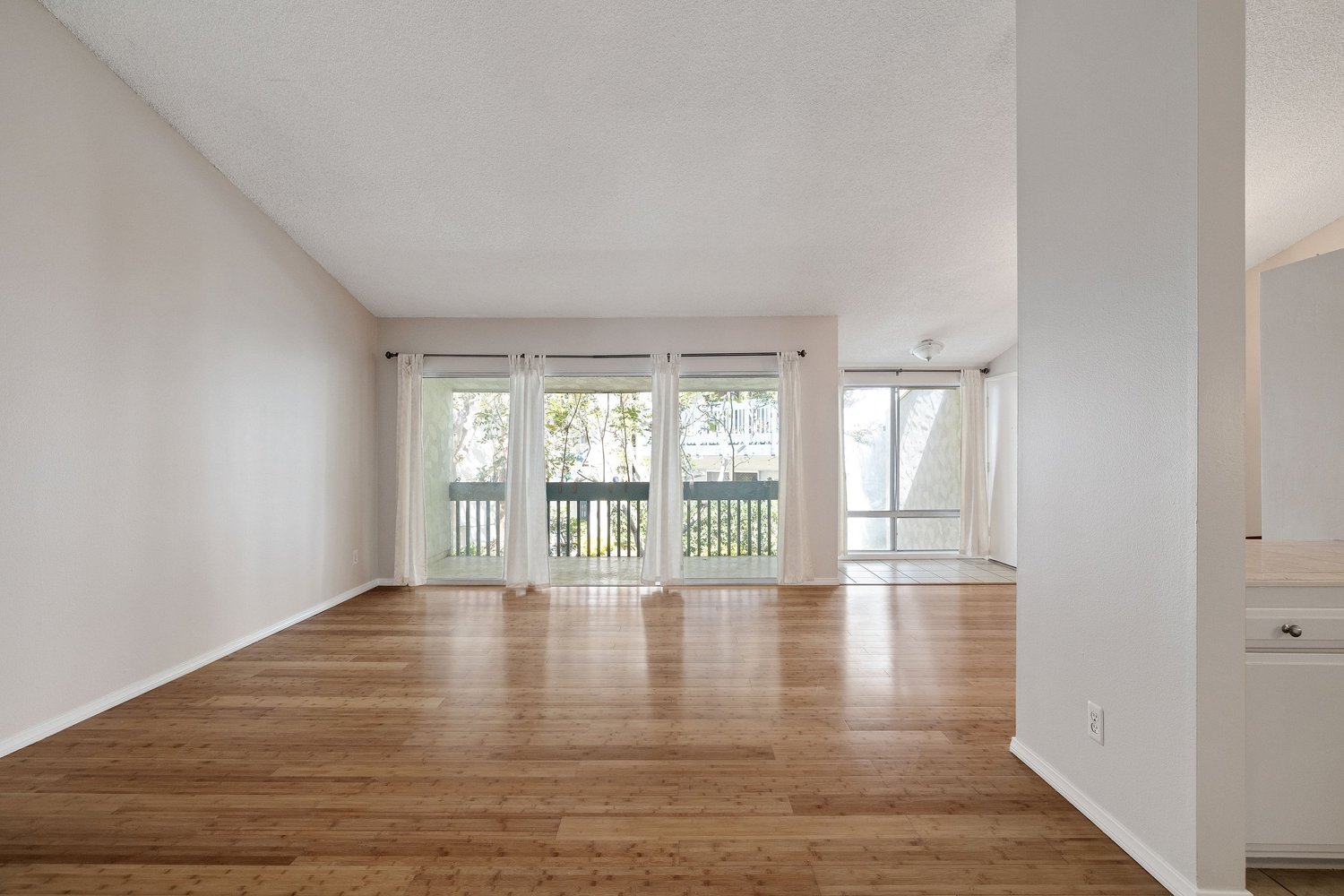 Living room with bamboo floors and sliding doors to the balcony