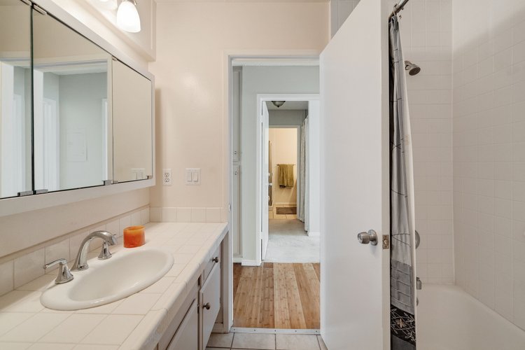 Bath vanity beside a tub with a shower curtain