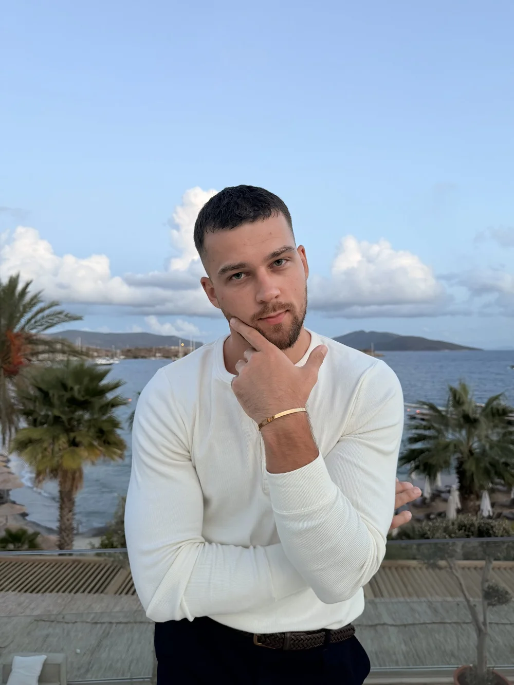 Oskar in a white knit by the water