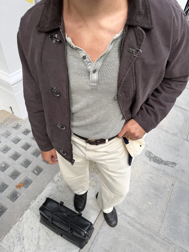 Brown jacket, cream trousers and holdall