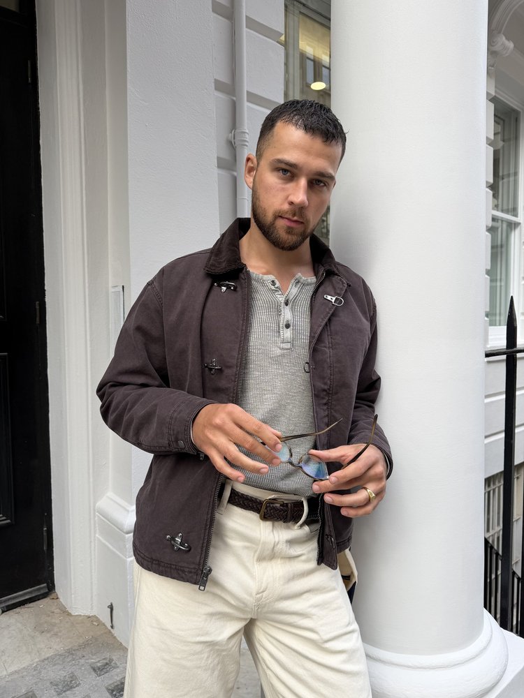Brown jacket against a white column