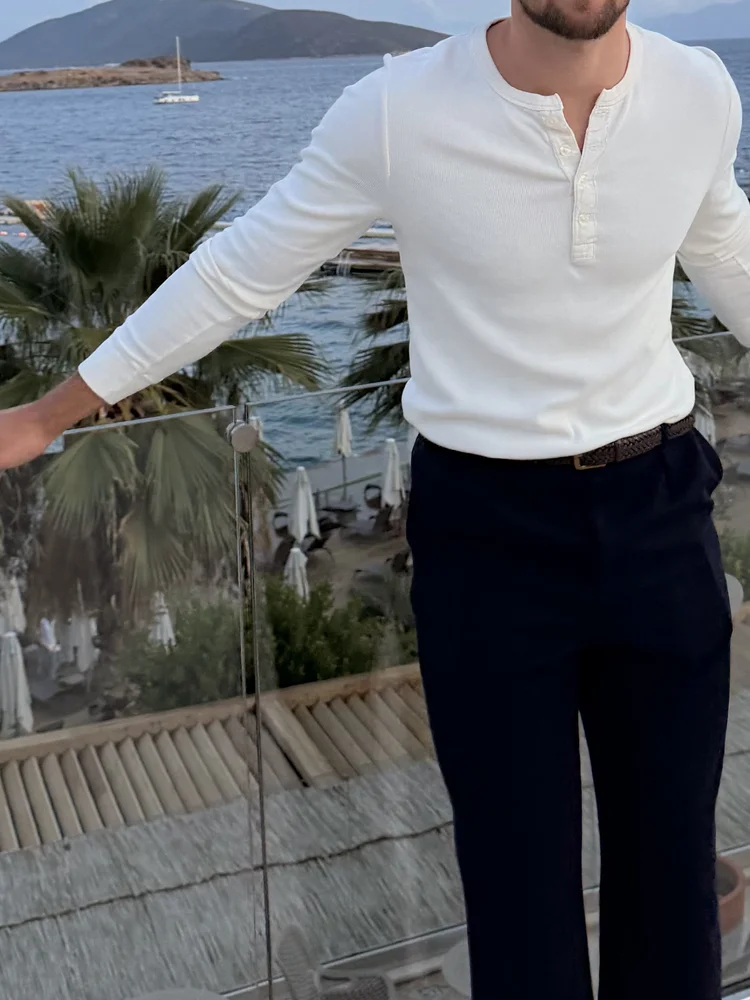 White henley and navy trousers by the sea