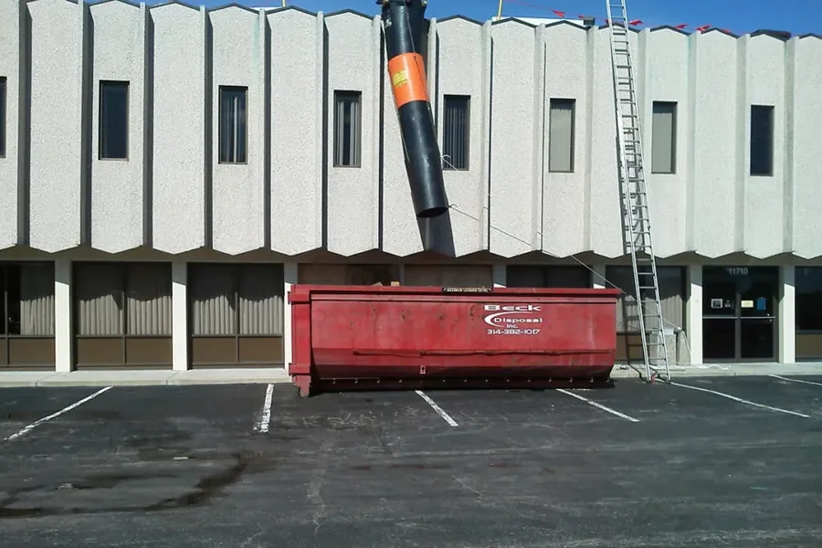 Beck container beneath a debris chute at a commercial roofing project