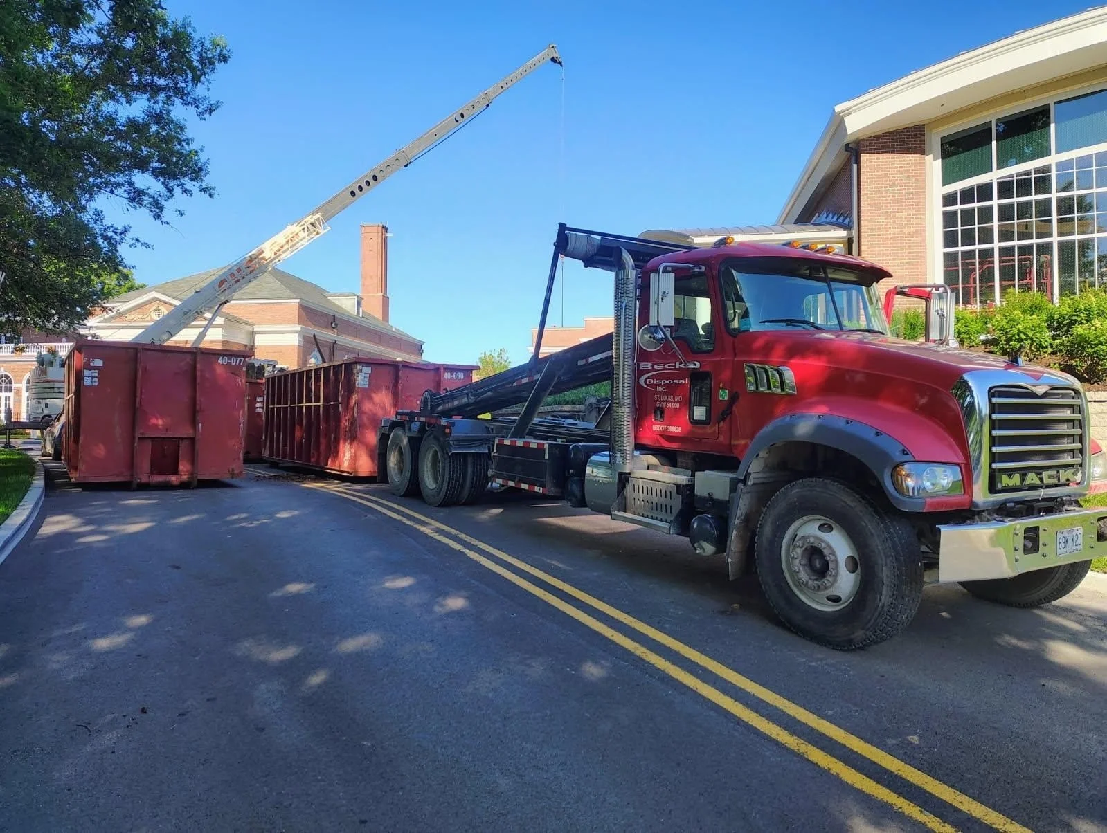 Beck roll-off truck and containers supporting a construction project with a crane