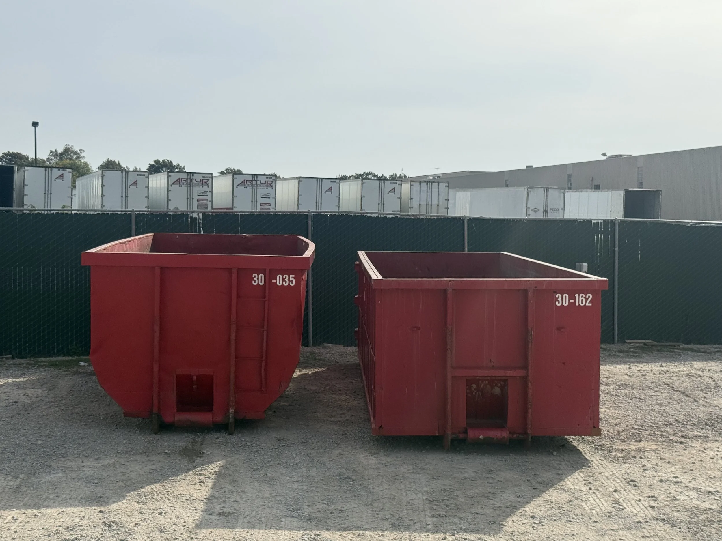 Two 30-yard Beck containers side by side: round-bottom style on the left and standard rectangular style on the right.