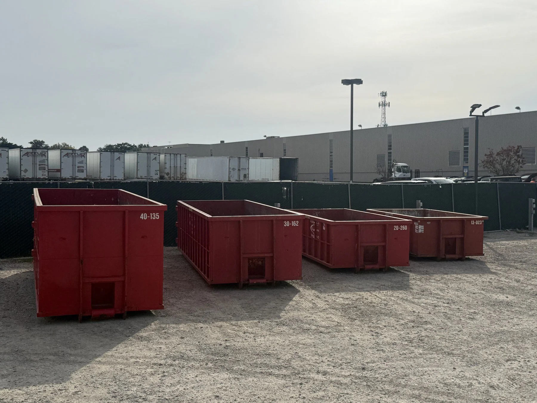 Four red Beck open-top containers of different sizes viewed at an angle