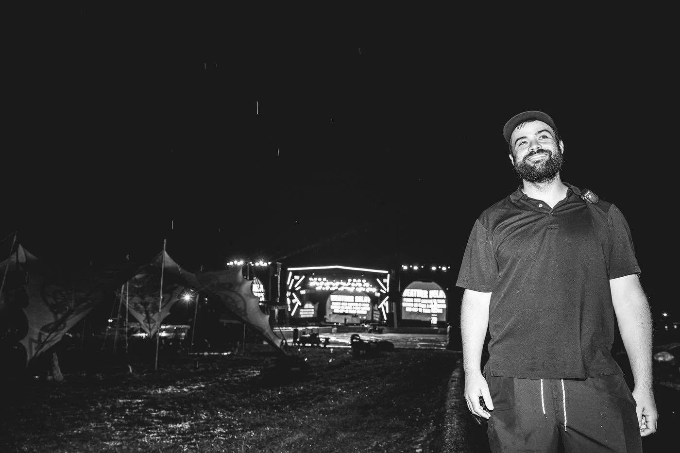 Founder Chris Salvato with a radio, in front of a festival main stage showing a weather delay