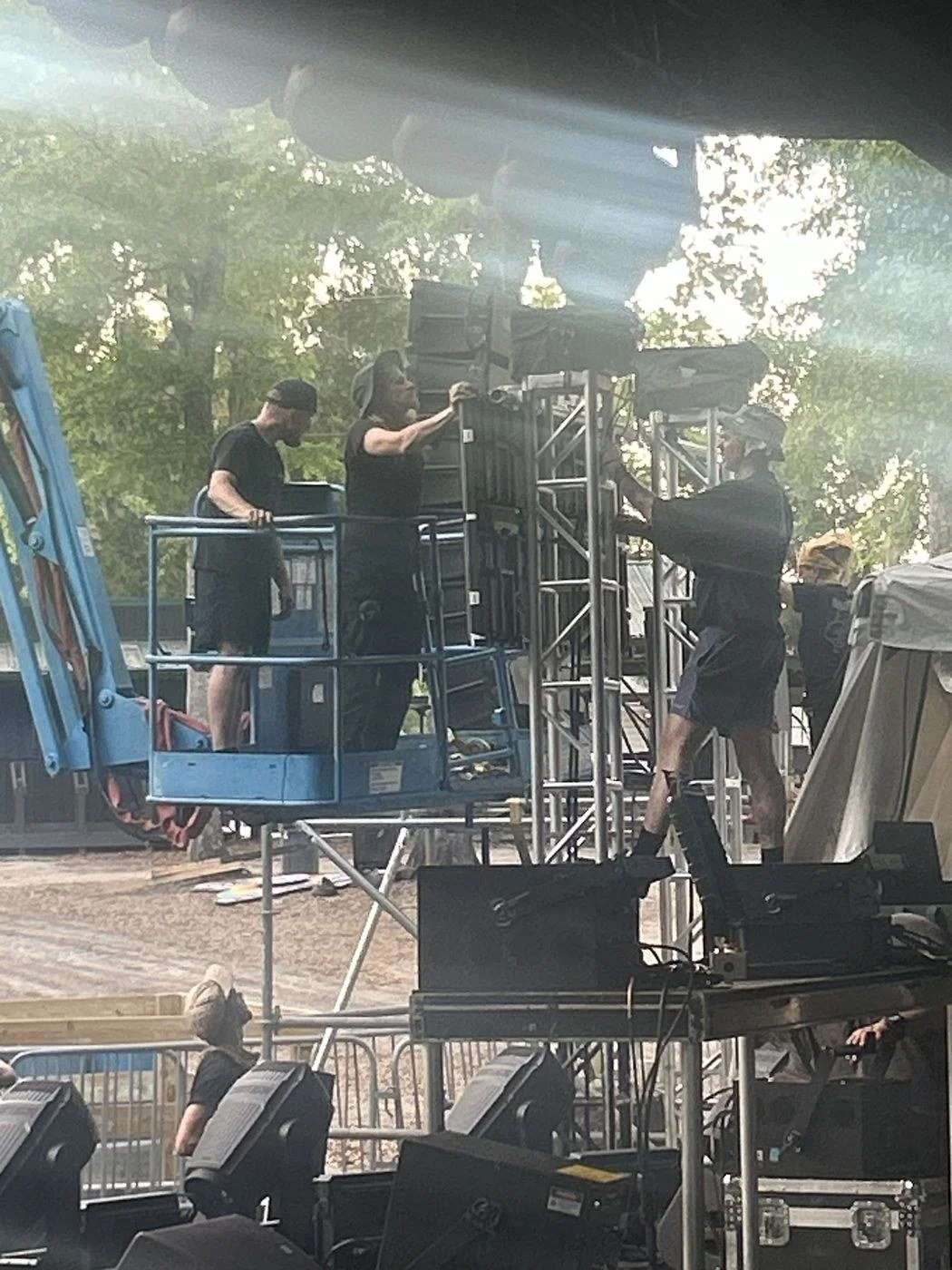 LED video techs in a boom lift hanging LED wall panels at an outdoor festival stage