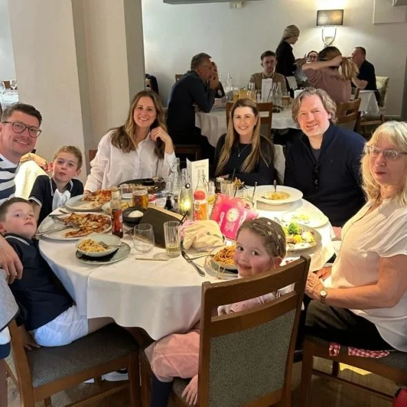 A family Sunday lunch at a round table, children and grandparents together