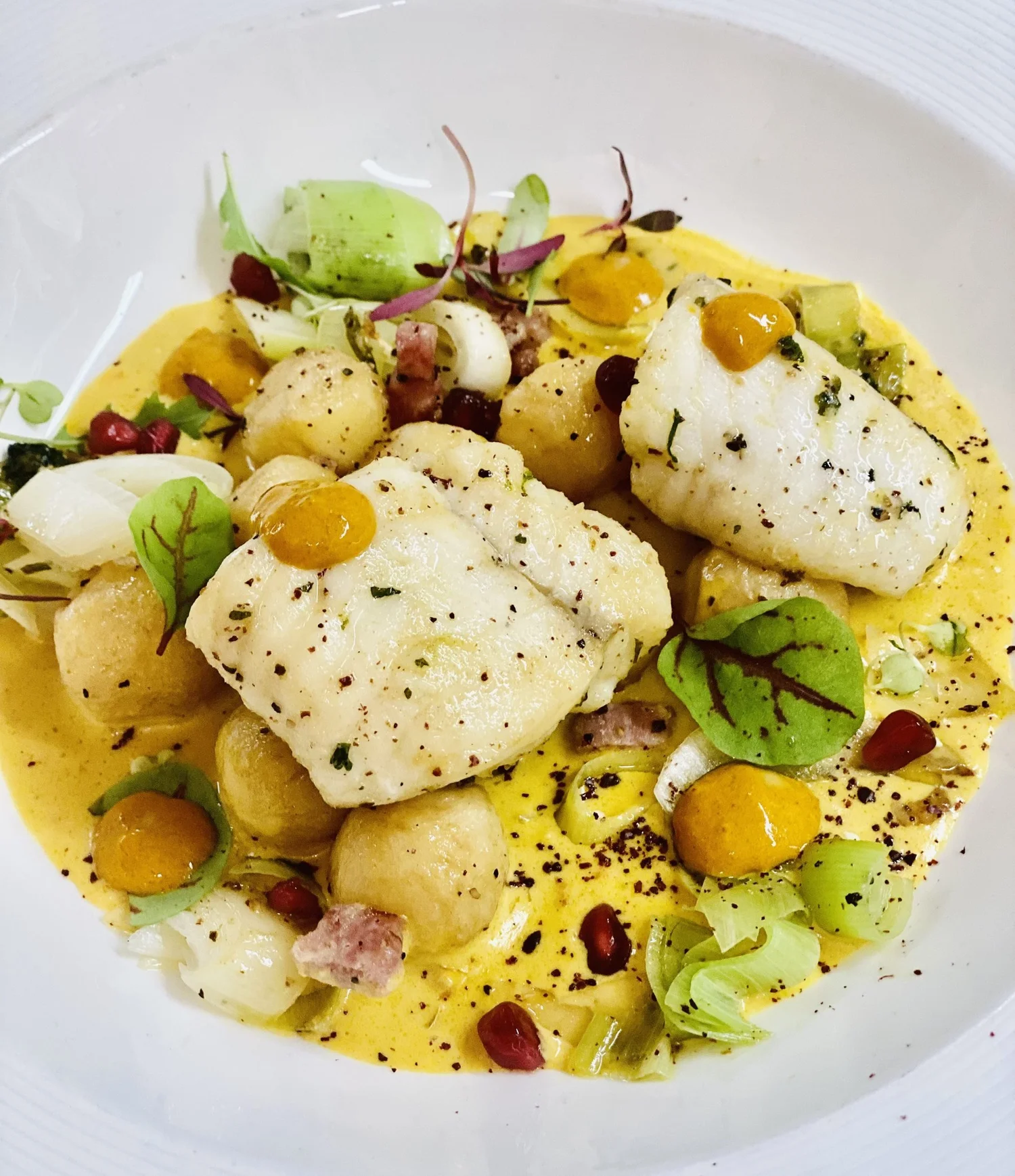 White fish with gnocchi in a saffron sauce