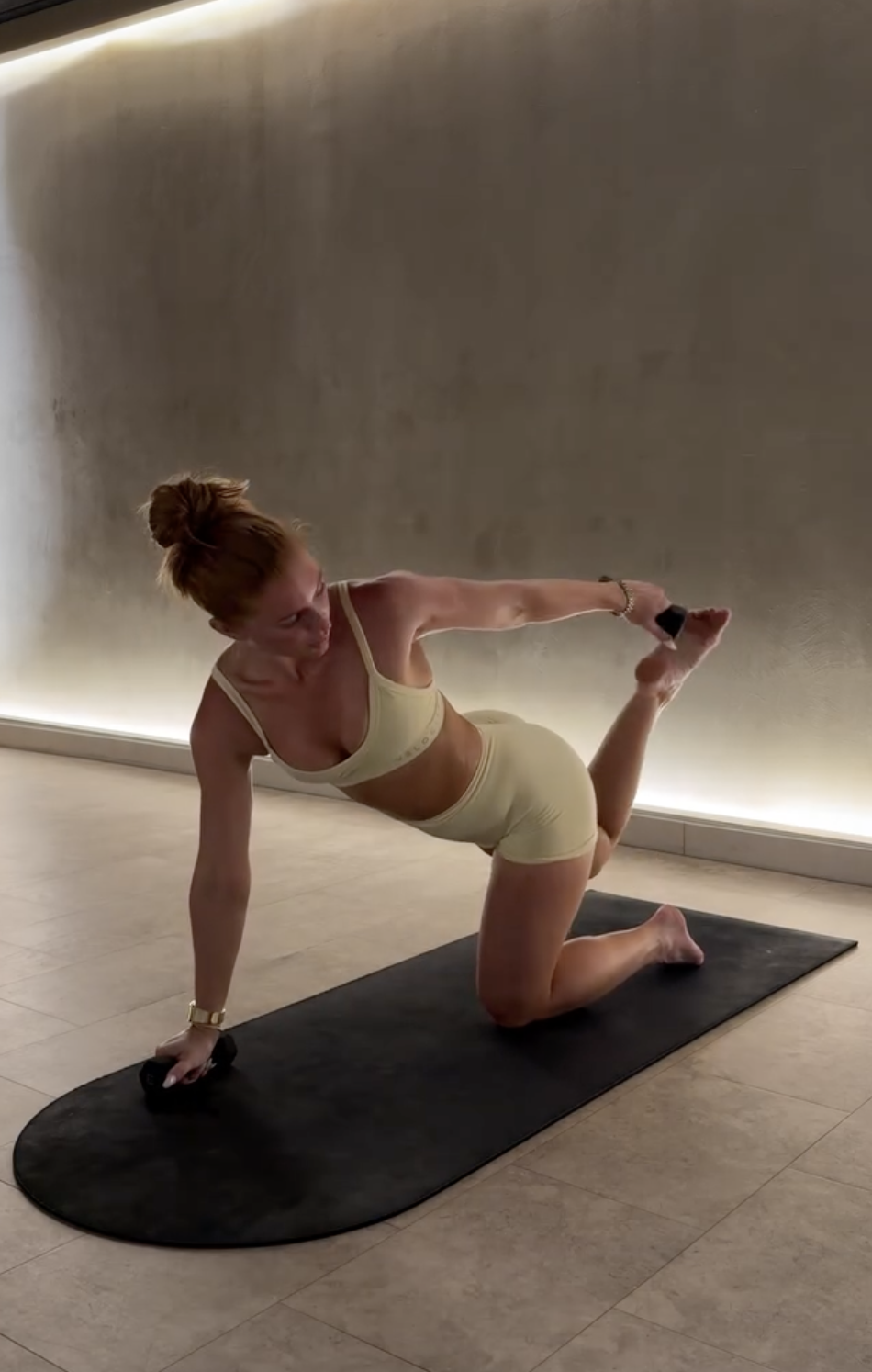 Yavay in a kneeling side kick with a light weight