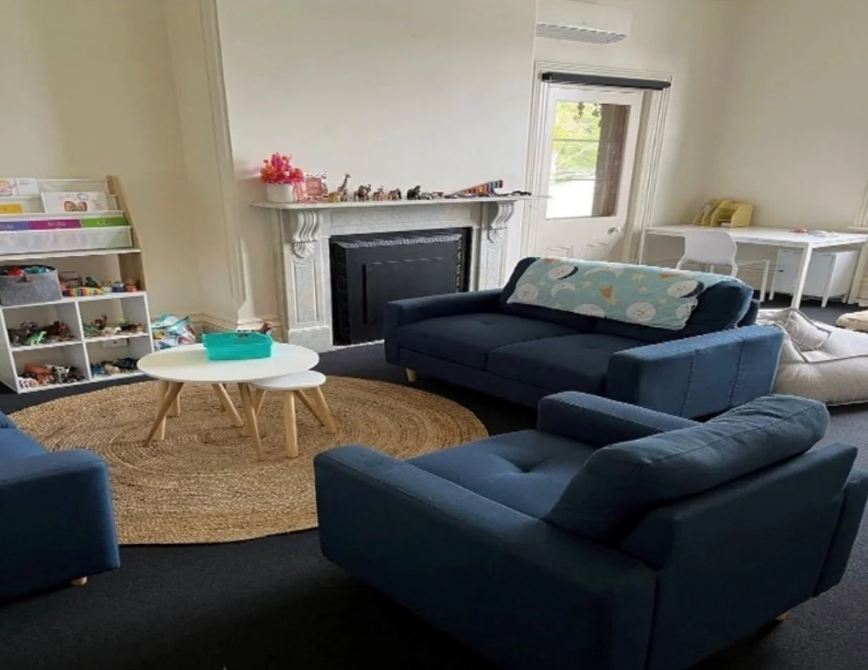 Inviting therapy room at Ariston House with sofas, fireplace and toys