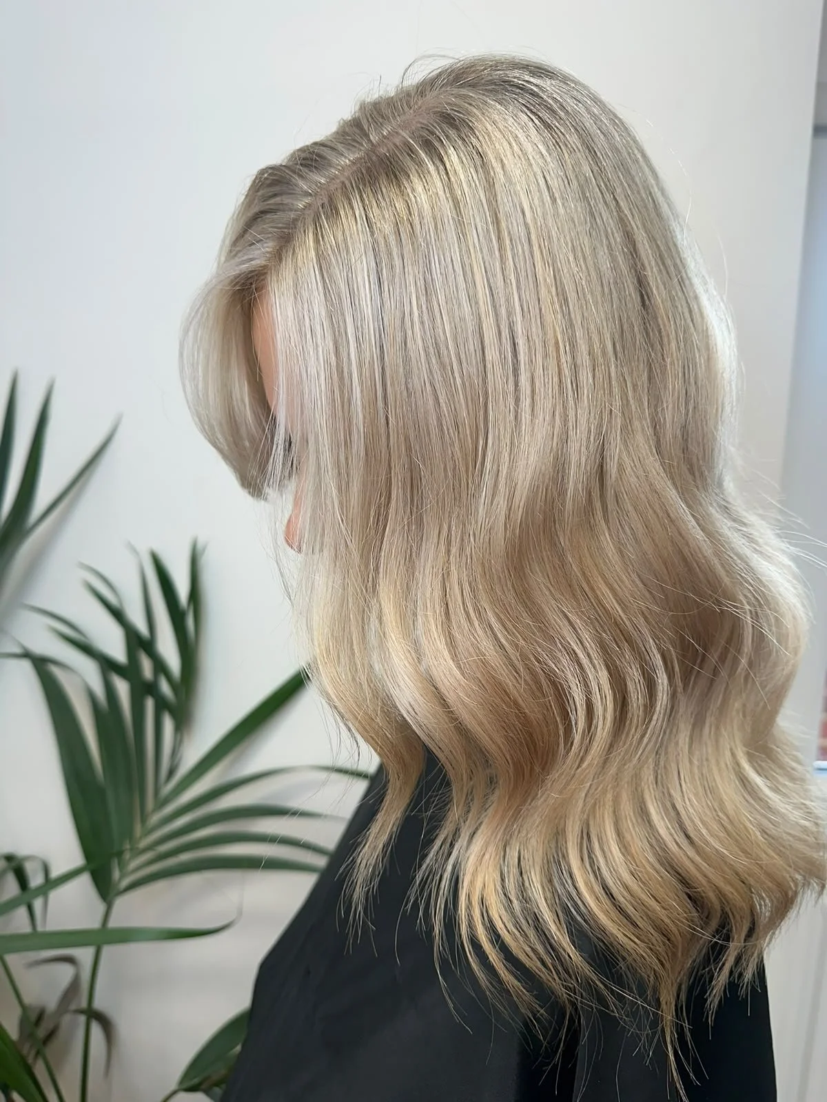 Long, glossy brunette hair in soft waves, cut at Escape
