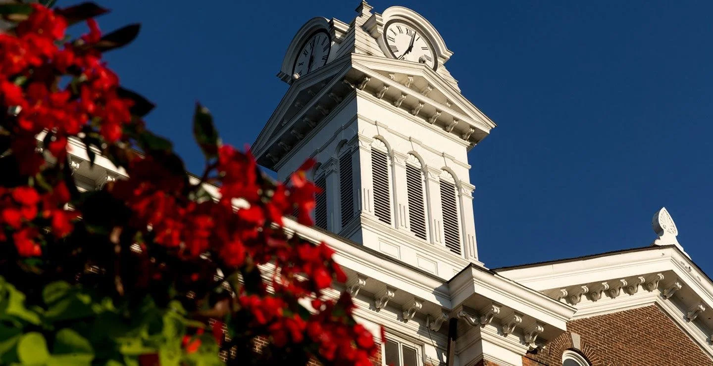 Kutztown University’s Old Main clock tower framed by red flowers