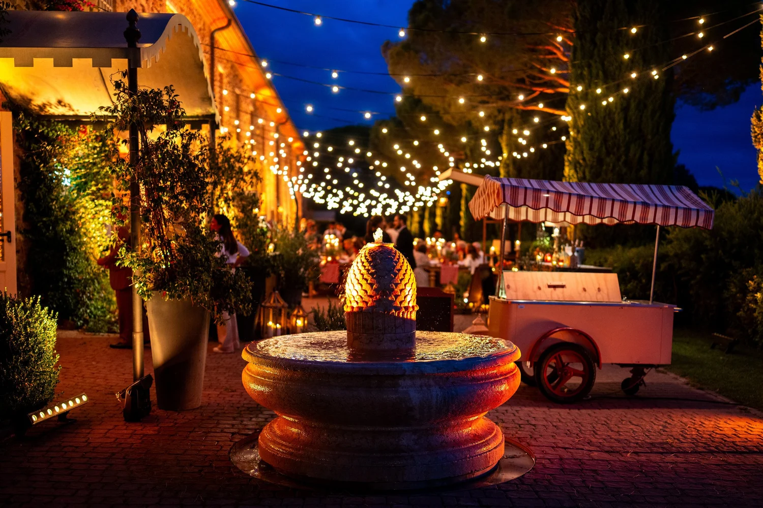 Brunnen und Lichterketten im Innenhof am Abend