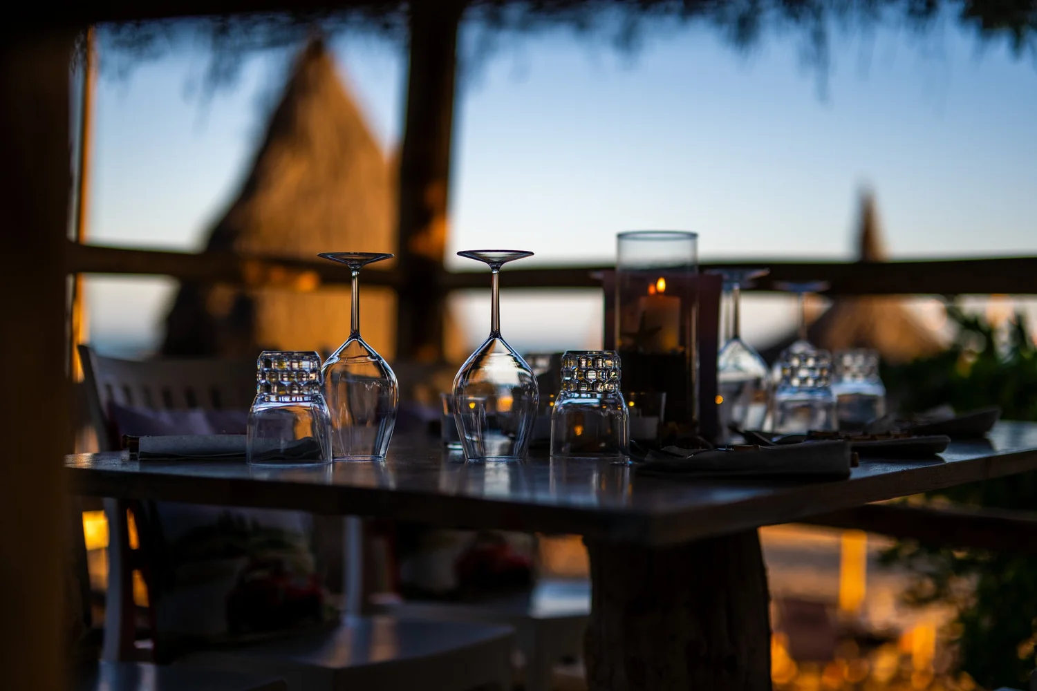 Gedeckte Tafel am Abend mit Gläsern im Gegenlicht