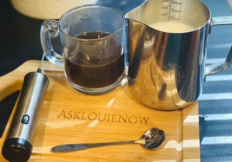 Coffee, a Zulay milk pitcher and frother on Louie's engraved AskLouieNow cutting board