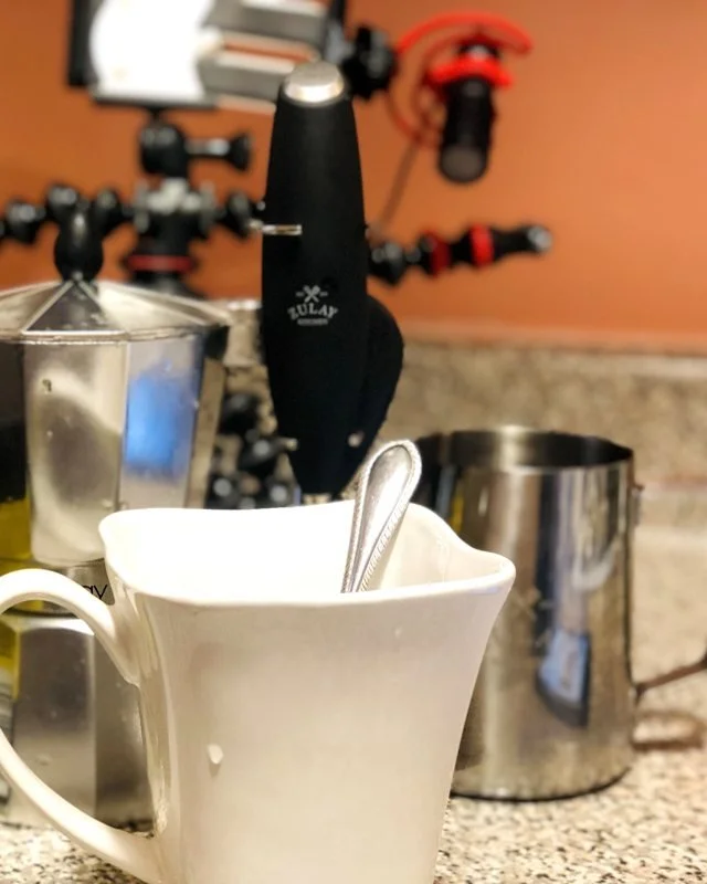 The first Coffee Time setup in Louie's Bronx apartment: orange wall, phone holder, frother and mug