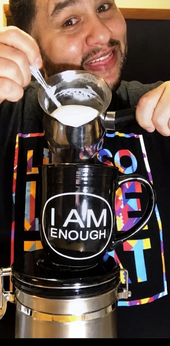 Louie pouring the froth into his I AM ENOUGH mug