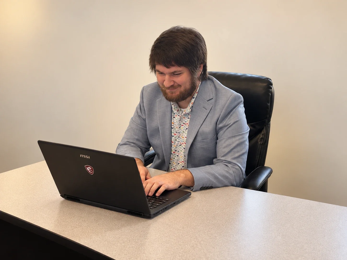 A SouthSites co-owner working at a laptop, with the desk in view.