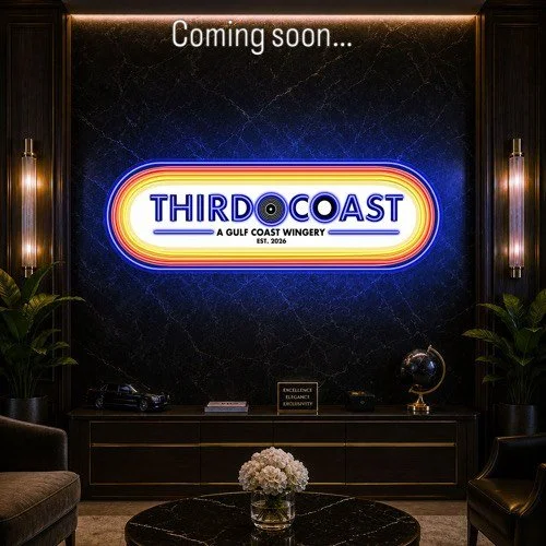 Glowing Third Coast sign on a dark navy wall, announcing coming soon