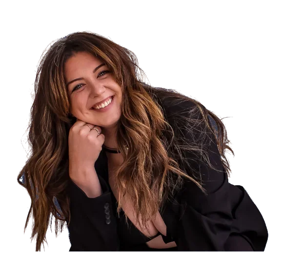 Jamie MacDonald smiling, chin resting on her hand, in a black blazer.