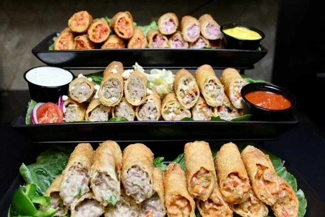 A selection of golden AGMar appetizer rolls, sliced and served on black platters