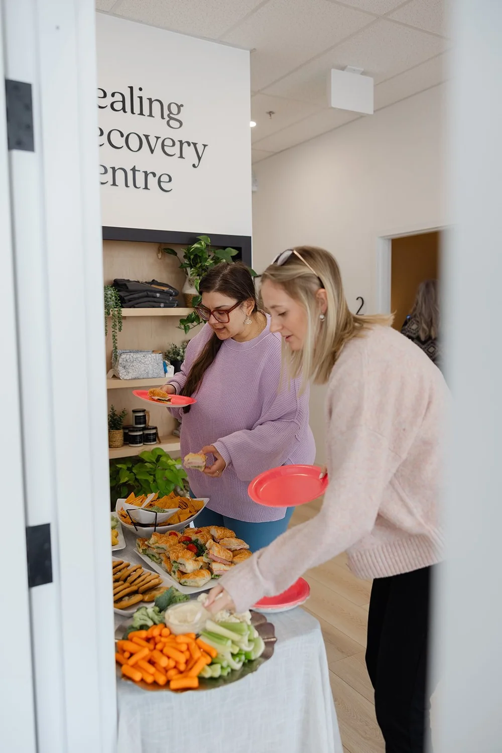 Guests serving themselves from a snack table in the Healing Recovery Centre entry