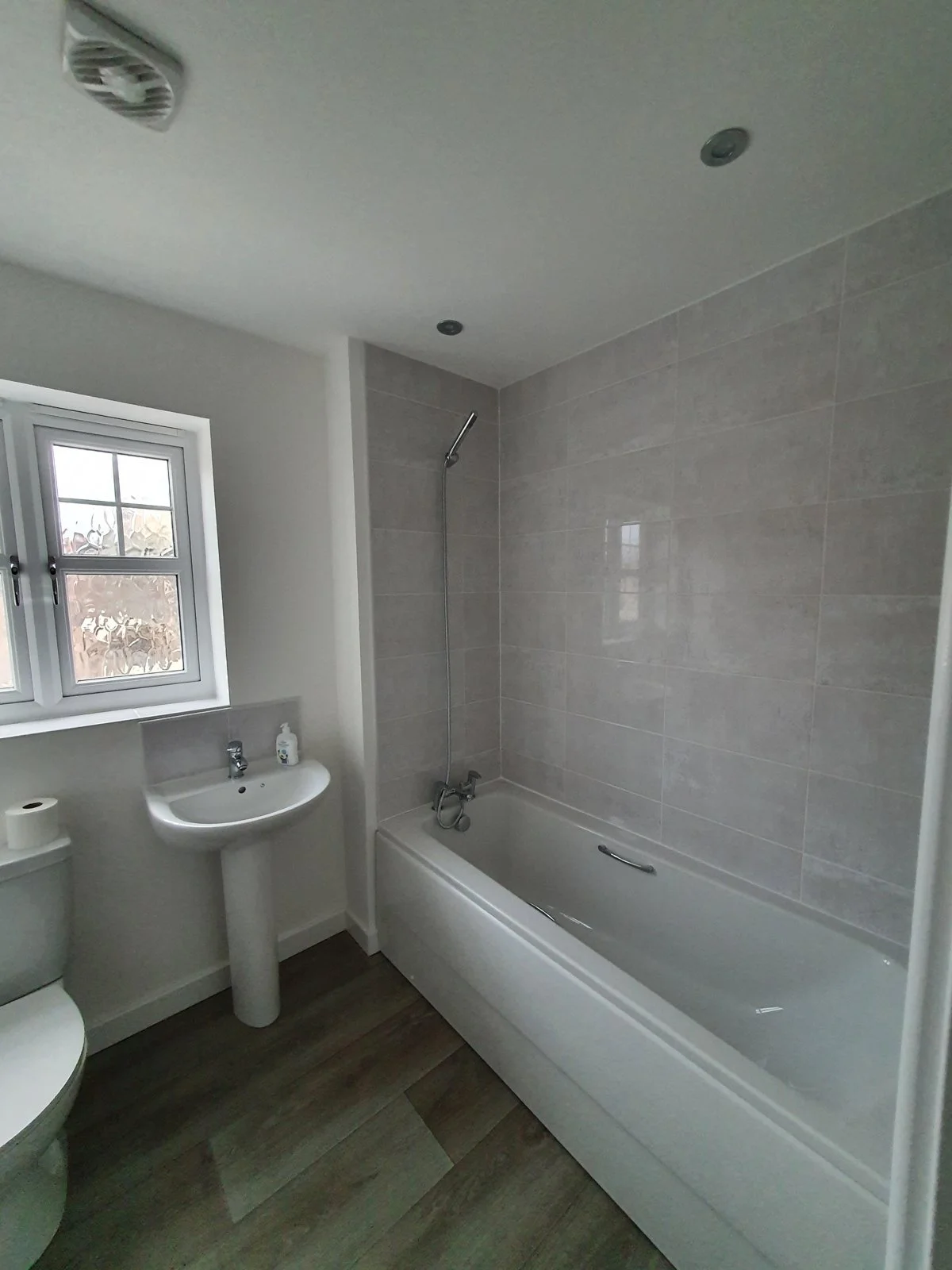 A bathroom with a bath, shower and basin