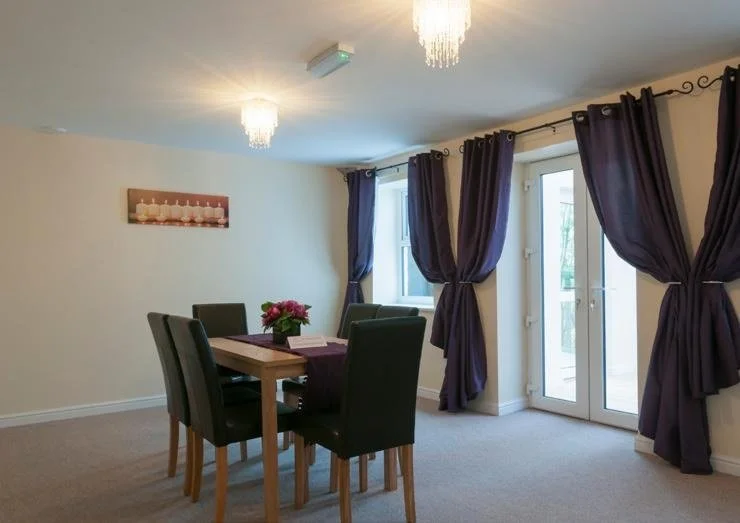 A dining table and chairs by French doors